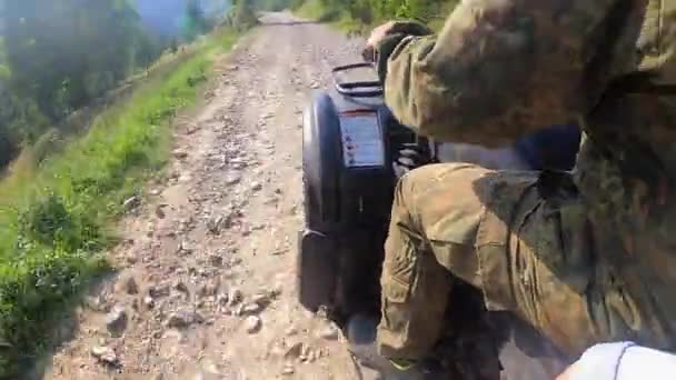 男は晴れた夏の日に山の上に未舗装の道路でクワッドバイクに乗る — ストック動画