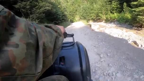 Mann fährt an sonnigem Sommertag Quad auf Feldweg auf Berg — Stockvideo