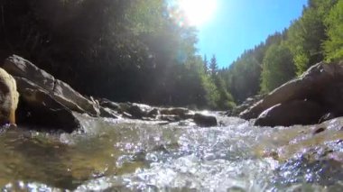 Çok güzel bir dağ manzarası, akan bir nehir ve parlak bir yansıması var.