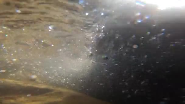 Oude stenen bedekt met muilezels en bruin slib liggen op de bodem van de rivier — Stockvideo