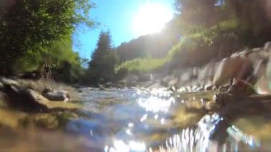 Çok güzel bir dağ manzarası, akan bir nehir ve parlak bir yansıması var.