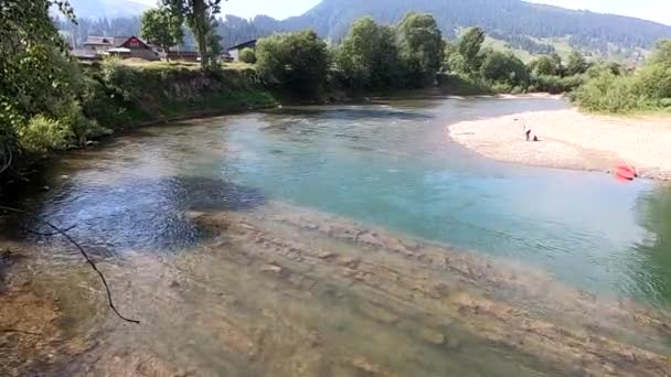 Río con enorme pedazo de roca piedra de acantilado de montaña en el fondo — Vídeos de Stock