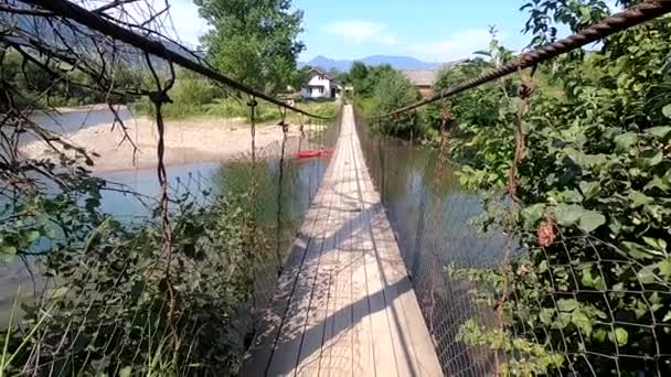 Berg landskap hängbro flödande flod — Stockvideo