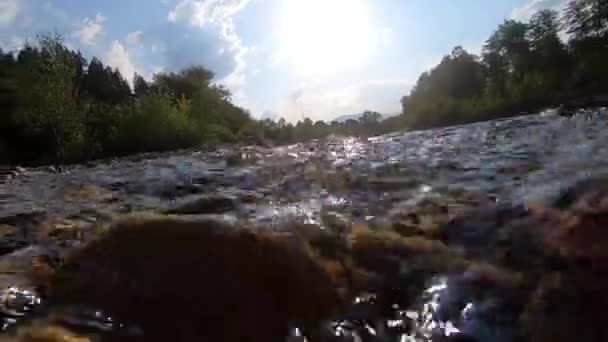 Kameran sjunker ner i vattnet. Abstrakt vy över strömmande flod, bokeh vit fläck — Stockvideo