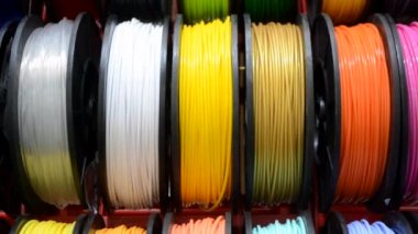 3D yazıcıya yakın çekimde yazdırmak için çok renkli plastik iplikler