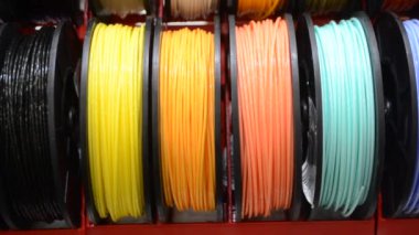 3D yazıcıya yakın çekimde yazdırmak için çok renkli plastik iplikler