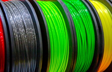 3D yazıcıya yakın çekimde yazdırmak için çok renkli plastik iplikler