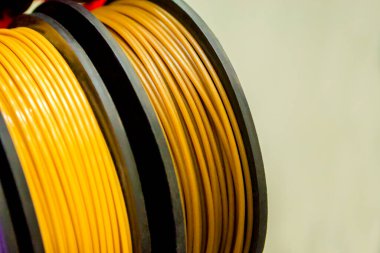 3D yazıcıya yakın çekimde yazdırmak için çok renkli plastik iplikler