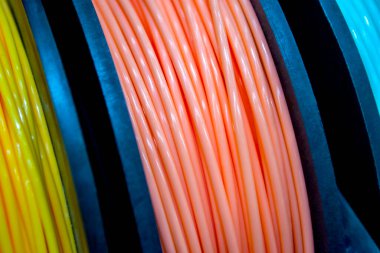 3D yazıcıya yakın çekimde yazdırmak için çok renkli plastik iplikler