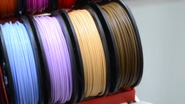 3D yazıcıya yakın çekimde yazdırmak için çok renkli plastik iplikler