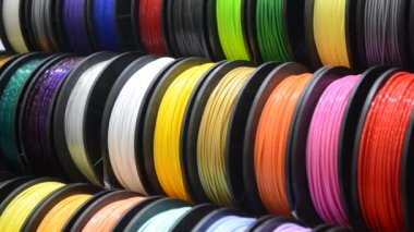 3D yazıcıya yakın çekimde yazdırmak için çok renkli plastik iplikler