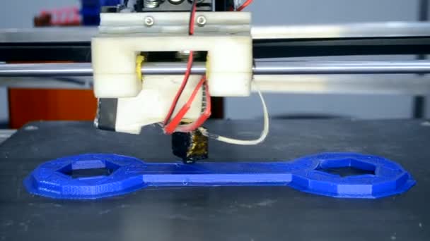 3d printer prints blue object model orange color close-up. — Stock Video