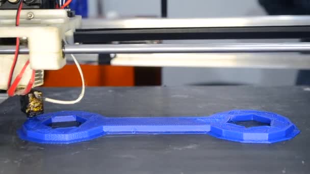 3d printer prints blue object model orange color close-up. — Stock Video