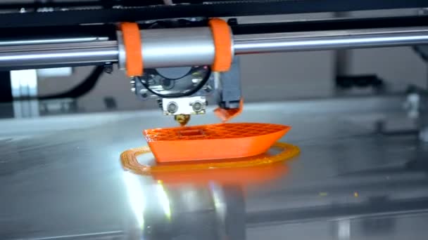 3d 프린터가 주황색 물체 모델을 프린트하고 있습니다. 주황색 색을 클로즈업 해서. — 비디오