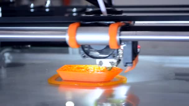 3D принтер печатает оранжевый объект модели оранжевый цвет крупным планом. — стоковое видео