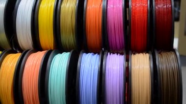 3D yazıcıya yakın çekimde yazdırmak için çok renkli plastik iplikler