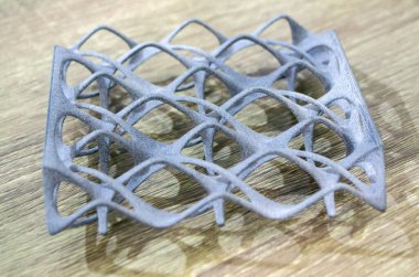 Podyum tozunun 3D yazıcısında yakın plan çekilmiş bir nesne. Termoplastik gri renkten üç boyutlu model. Hızlı prototip, baskı ürünleri. İlerici modern katkı teknolojisi