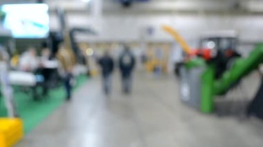 Arka plan bulanık. İnsanlar büyük uzay binasının içinde yürürler.