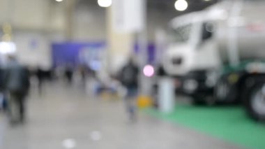 Arka plan bulanık. İnsanlar büyük uzay binasının içinde yürürler.
