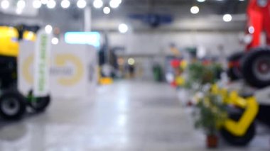Arka plan bulanık. İnsanlar büyük uzay binasının içinde yürürler.