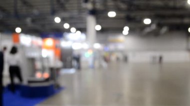 Arka plan bulanık. İnsanlar büyük uzay binasının içinde yürürler.