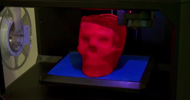Череп напечатан пластмассой красного цвета на 3D принтере. Внутри 3D принтера, — стоковое видео
