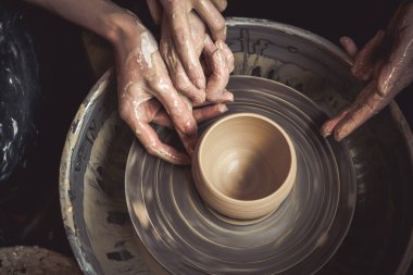 Çömlekçi ustasının elleri ve çömlekçinin çarkına konmuş vazo. Efendi Crock. Çarpık çömlekçi çarkı.