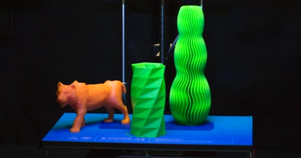 Los objetos impresos impresora 3D en un fondo azul y negro — Vídeo de stock