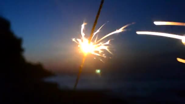 Bengalisches Feuer mit Funken brennt nachts in der Dämmerung vor dem Hintergrund — Stockvideo