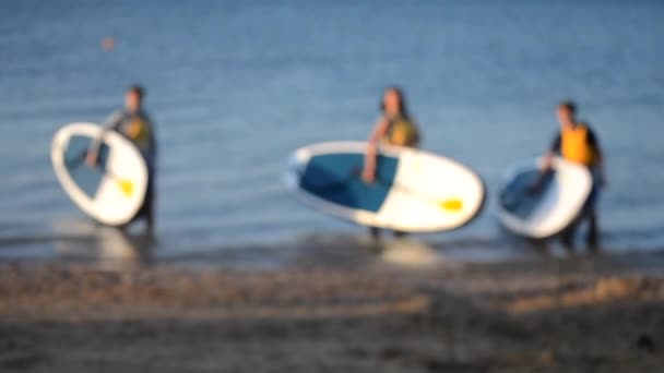 Wazige achtergrond. Veel mensen staan op zee en nemen foto 's met sup board — Stockvideo