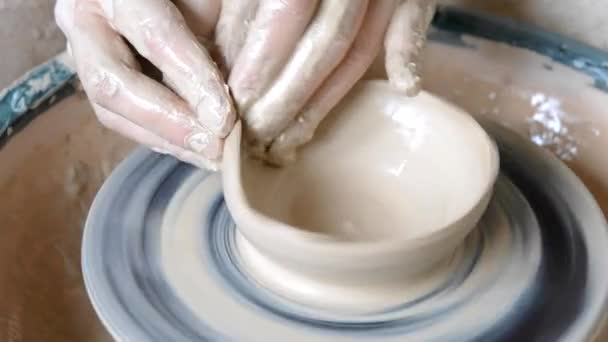 Woman girl with her hands dub wall jug, which she sculpts out of clay on circle — Stock Video