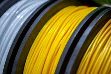 3D yazıcıya yakın çekimde basmak için çok renkli plastik iplikler. 3D yazıcı makaraları farklı renkte termoplastik iplik. Motley ABS kablo plastiği 3D yazıcı için. Katkı teknolojisi