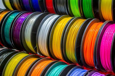 Multicolored filaments of plastic for printing on 3D printer close-up. Spools of 3D printing motley different colors thermoplastic filament. Motley ABS wire plastic for 3d printer. Additive technology clipart