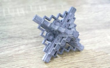 Podyum tozunun 3D yazıcısında yakın plan çekilmiş bir nesne. Termoplastik gri renkten üç boyutlu model. Hızlı prototip, baskı ürünleri. İlerici modern katkı teknolojisi