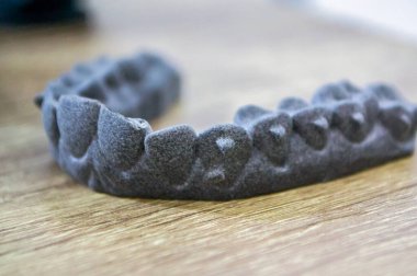 Podyum tozunun 3D yazıcısında yakın plan çekilmiş bir nesne. Termoplastik gri renkten üç boyutlu model. Hızlı prototip, baskı ürünleri. İlerici modern katkı teknolojisi