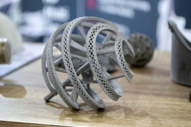 Podyum tozunun 3D yazıcısında yakın plan çekilmiş bir nesne. Termoplastik gri renkten üç boyutlu model. Hızlı prototip, baskı ürünleri. İlerici modern katkı teknolojisi