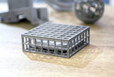 Podyum tozunun 3D yazıcısında yakın plan çekilmiş bir nesne. Termoplastik gri renkten üç boyutlu model. Hızlı prototip, baskı ürünleri. İlerici modern katkı teknolojisi