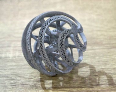 Podyum tozunun 3D yazıcısında yakın plan çekilmiş bir nesne. Termoplastik gri renkten üç boyutlu model. Hızlı prototip, baskı ürünleri. İlerici modern katkı teknolojisi