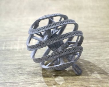 Podyum tozunun 3D yazıcısında yakın plan çekilmiş bir nesne. Termoplastik gri renkten üç boyutlu model. Hızlı prototip, baskı ürünleri. İlerici modern katkı teknolojisi