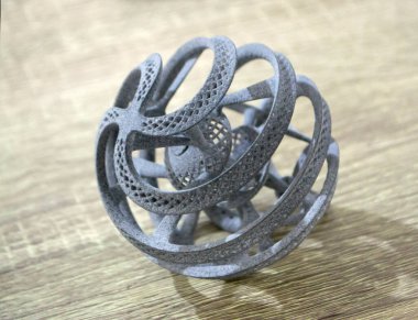 Podyum tozunun 3D yazıcısında yakın plan çekilmiş bir nesne. Termoplastik gri renkten üç boyutlu model. Hızlı prototip, baskı ürünleri. İlerici modern katkı teknolojisi