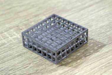 Podyum tozunun 3D yazıcısında yakın plan çekilmiş bir nesne. Termoplastik gri renkten üç boyutlu model. Hızlı prototip, baskı ürünleri. İlerici modern katkı teknolojisi