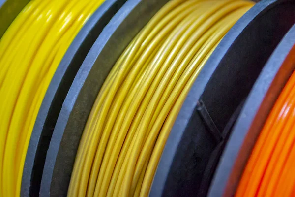 Multicolored filaments of plastic for printing on 3D printer close-up. Spools of 3D printing motley different colors thermoplastic filament. Motley ABS wire plastic for 3d printer. Additive technology