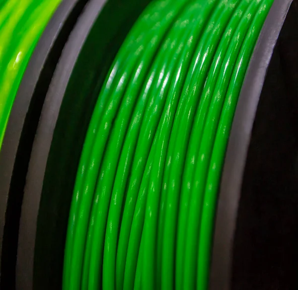 Multicolored filaments of plastic for printing on 3D printer close-up. Spools of 3D printing motley different colors thermoplastic filament. Motley ABS wire plastic for 3d printer. Additive technology