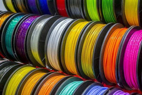 3D yazıcıya yakın çekimde basmak için çok renkli plastik iplikler. 3D yazıcı makaraları farklı renkte termoplastik iplik. Motley ABS kablo plastiği 3D yazıcı için. Katkı teknolojisi