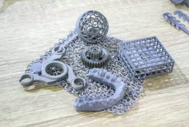 Podyum tozunun 3D yazıcısında yakın plan çekilmiş bir nesne. Termoplastik gri renkten üç boyutlu model. Hızlı prototip, baskı ürünleri. İlerici modern katkı teknolojisi