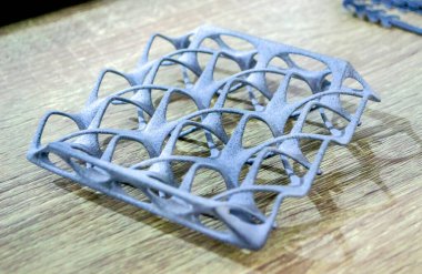 Podyum tozunun 3D yazıcısında yakın plan çekilmiş bir nesne. Termoplastik gri renkten üç boyutlu model. Hızlı prototip, baskı ürünleri. İlerici modern katkı teknolojisi