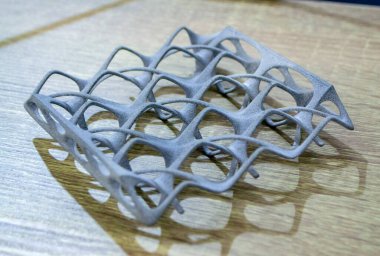 Podyum tozunun 3D yazıcısında yakın plan çekilmiş bir nesne. Termoplastik gri renkten üç boyutlu model. Hızlı prototip, baskı ürünleri. İlerici modern katkı teknolojisi