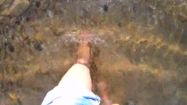 Dziewczyna chodzi boso po piaszczystym dnie z kamieniami na brzegu morza — Wideo stockowe