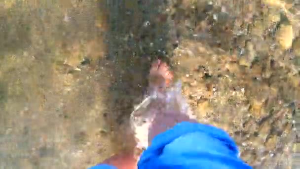 소녀는 해변의 돌을 들고 모래 바닥에서 맨 발로 걸어 다닌다 — 비디오