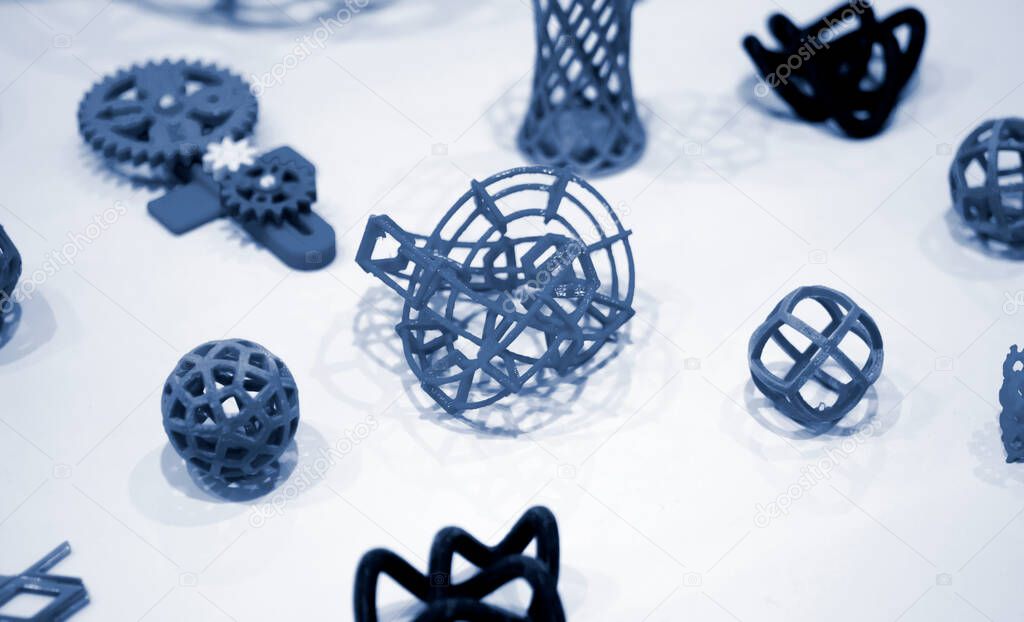 Many abstract models printed by 3d printer close-up.